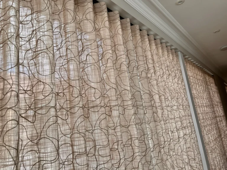 Sheer wave curtains in a looped line print running along a wall of windows