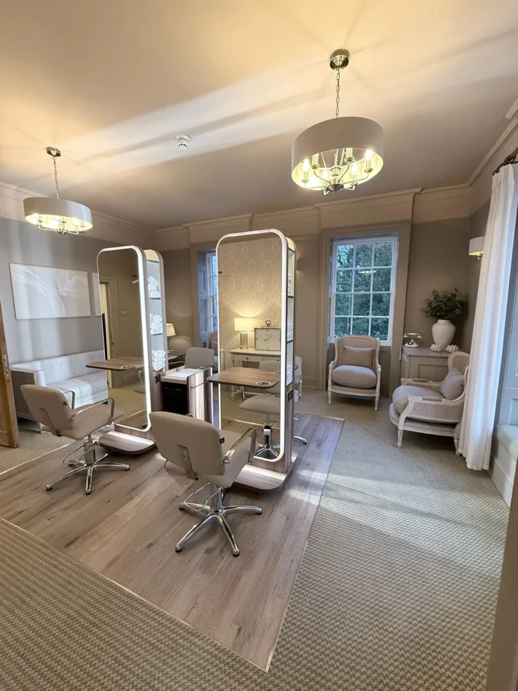 The Bridal Suite at Mulberry House, with two lit mirror stations, styling chairs and chandeliers in a period room