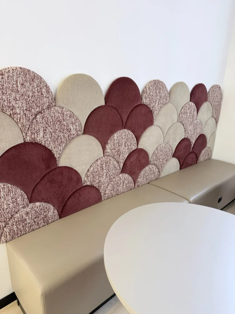 Scalloped upholstered wall panels in burgundy, cream and speckled fabrics above a fitted bench seat