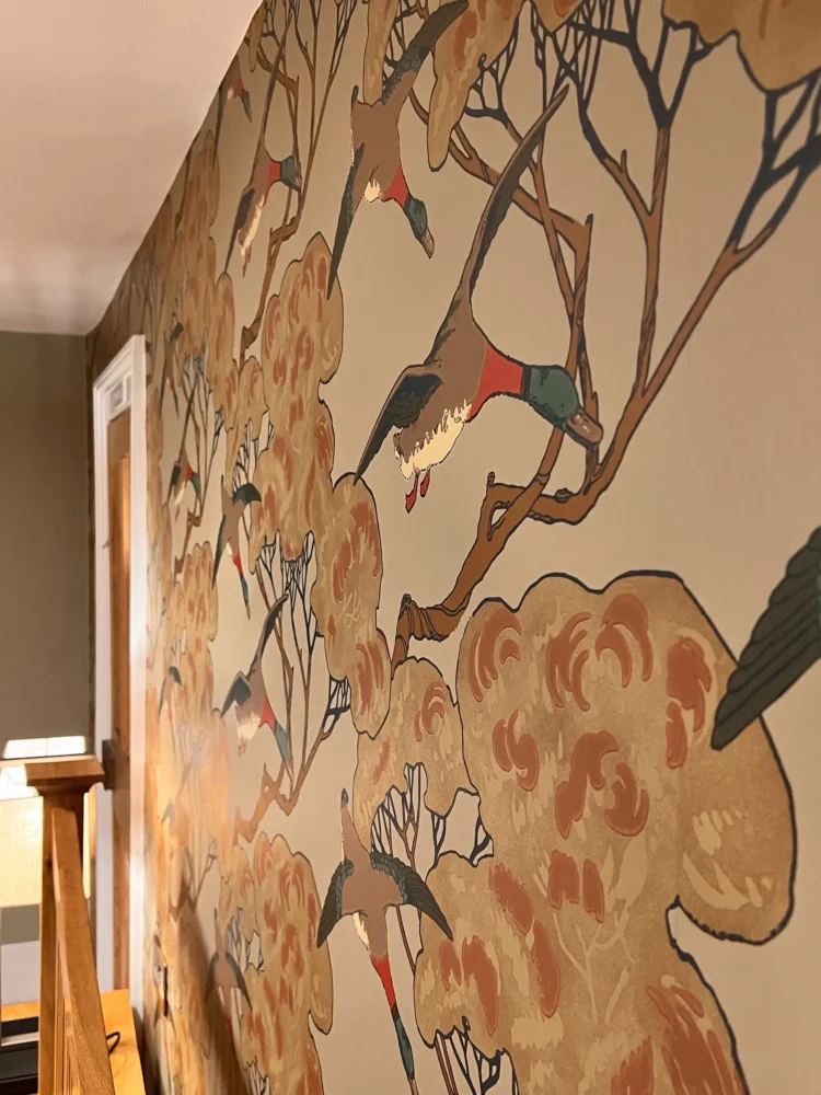 Close-up of bird and blossom wallpaper on a bedroom wall at Mulberry House