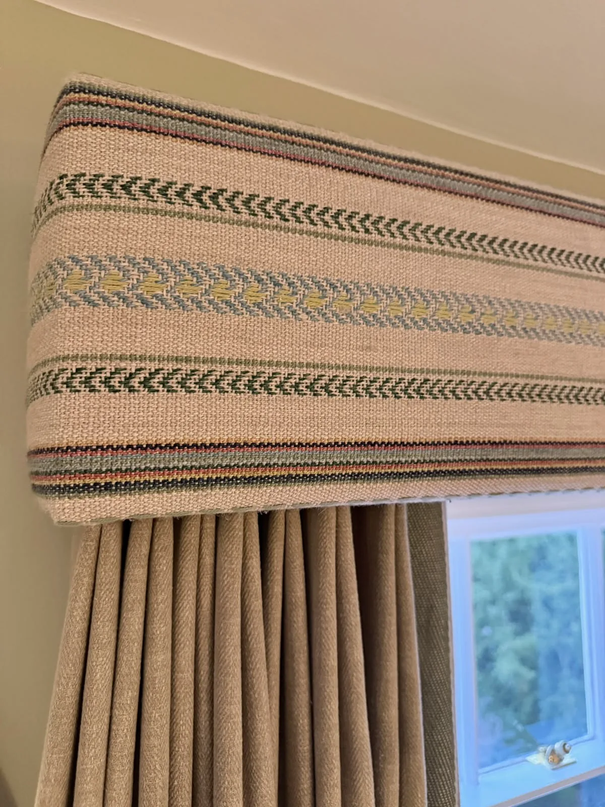 Close-up of a striped woven box pelmet above pleated curtains, in a bedroom at Mulberry House