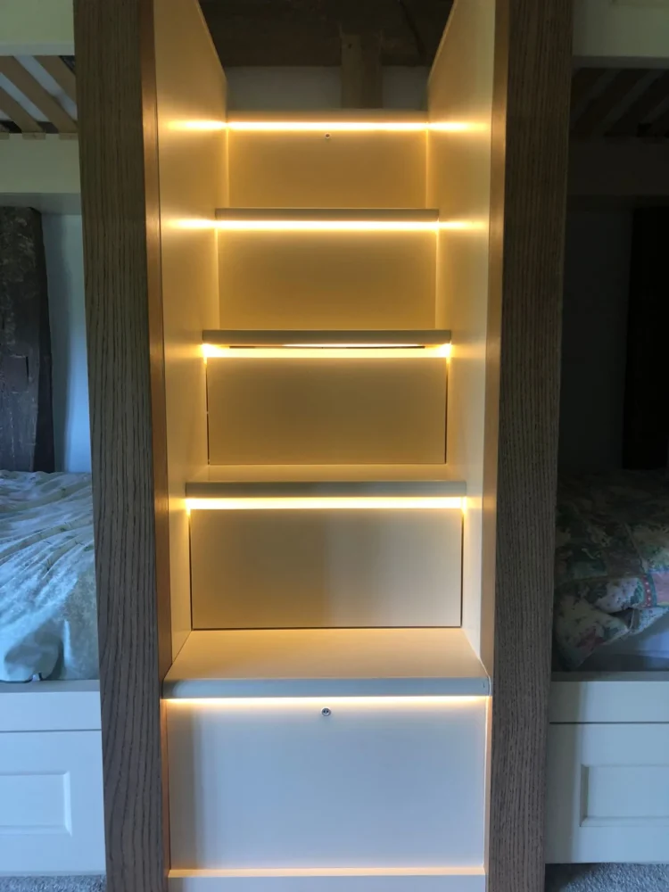 Built-in bunk bed steps with strip lighting between oak posts
